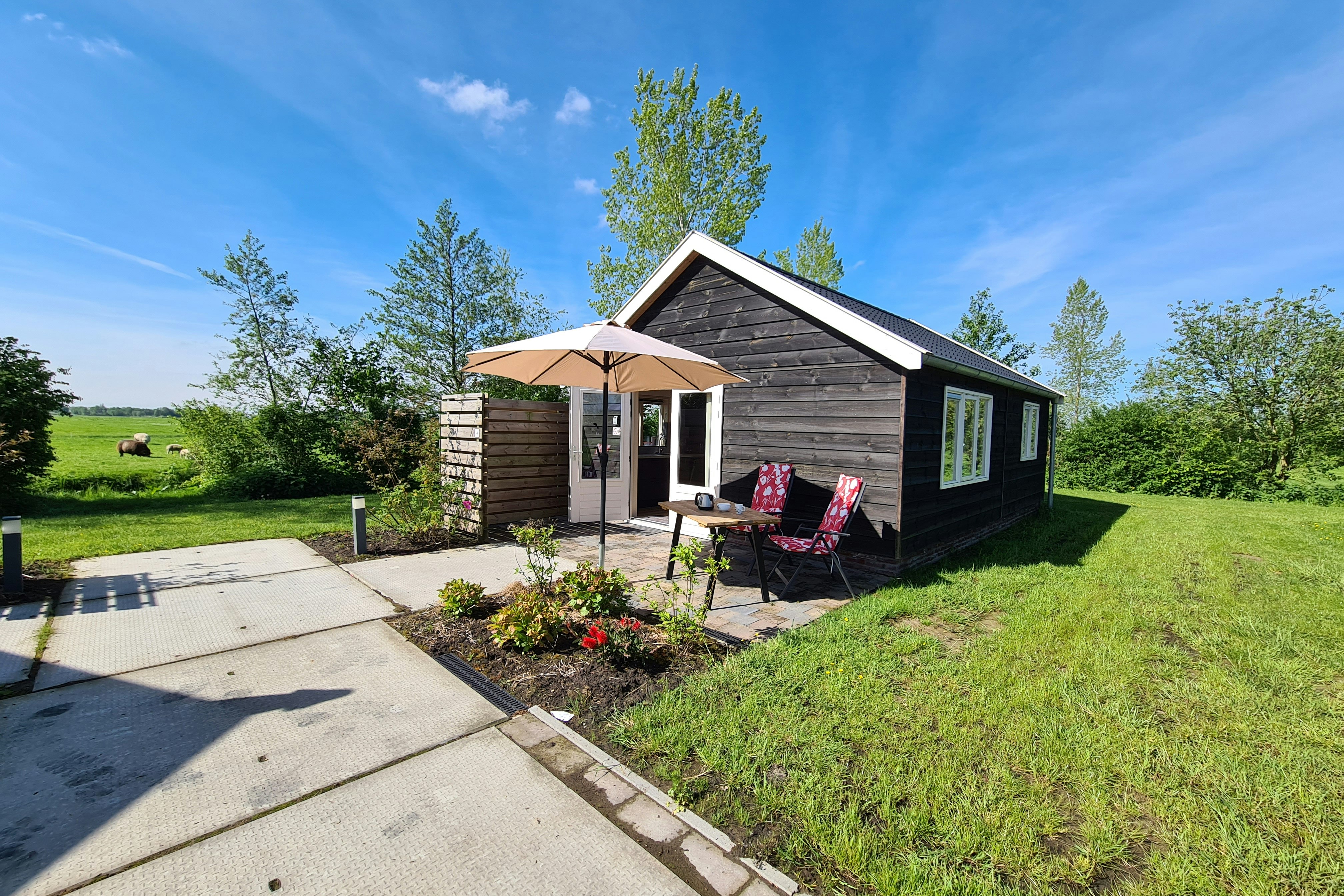 Minicamping De Kan Hoeve - Mobilheim mit kleiner Terrasse und Sonnenschirm