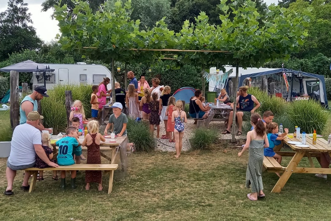 Minicamping De Vlaschaard - Gäste sitzen gemeinsam auf den Picknickbänken