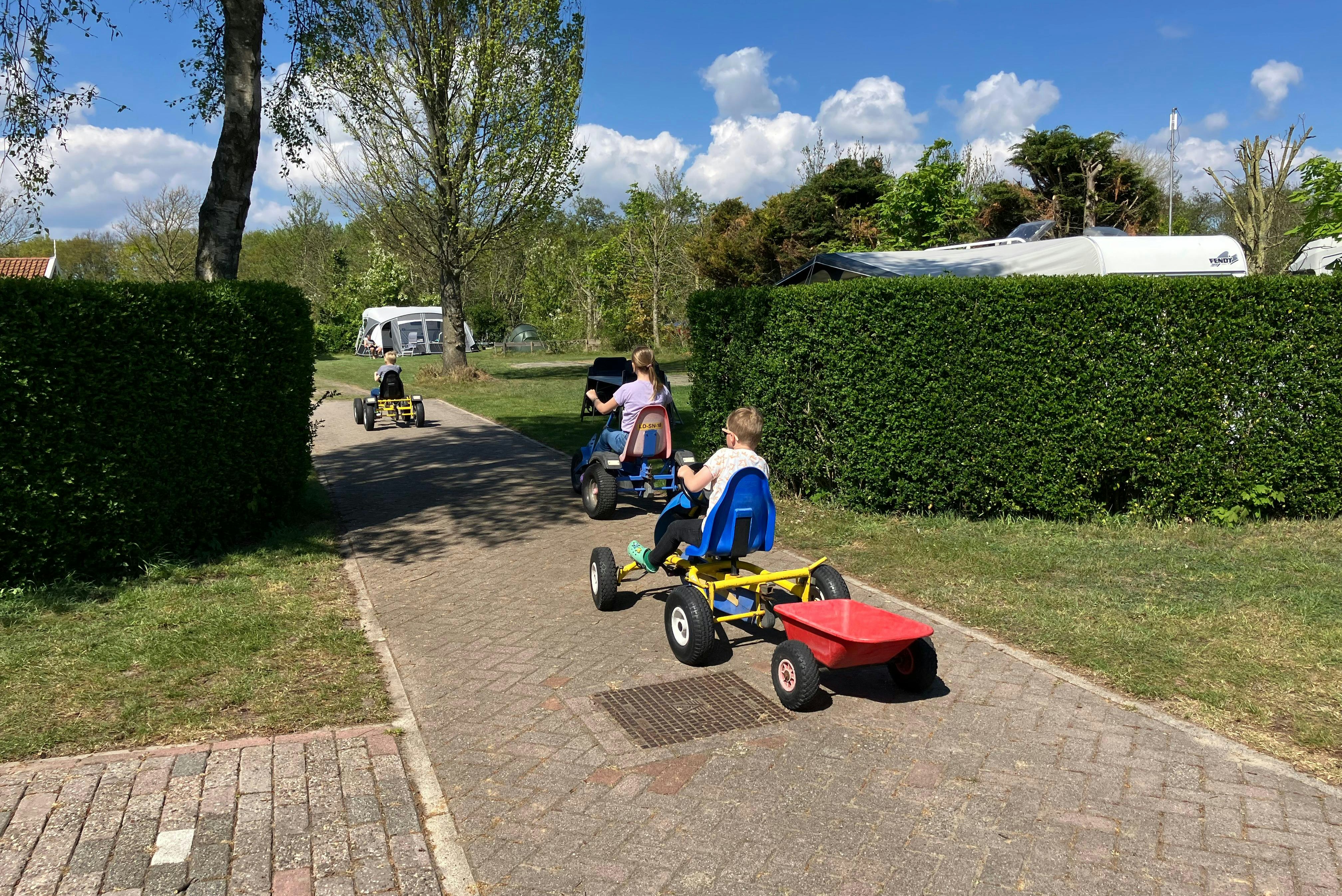 Minicamping de Westert - Kinder fahren mit Spielgeräten auf dem Campingplatz