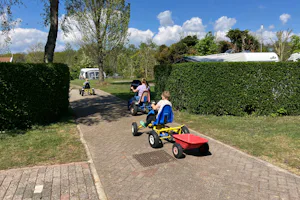 Minicamping de Westert - Kinder fahren mit Spielgeräten auf dem Campingplatz