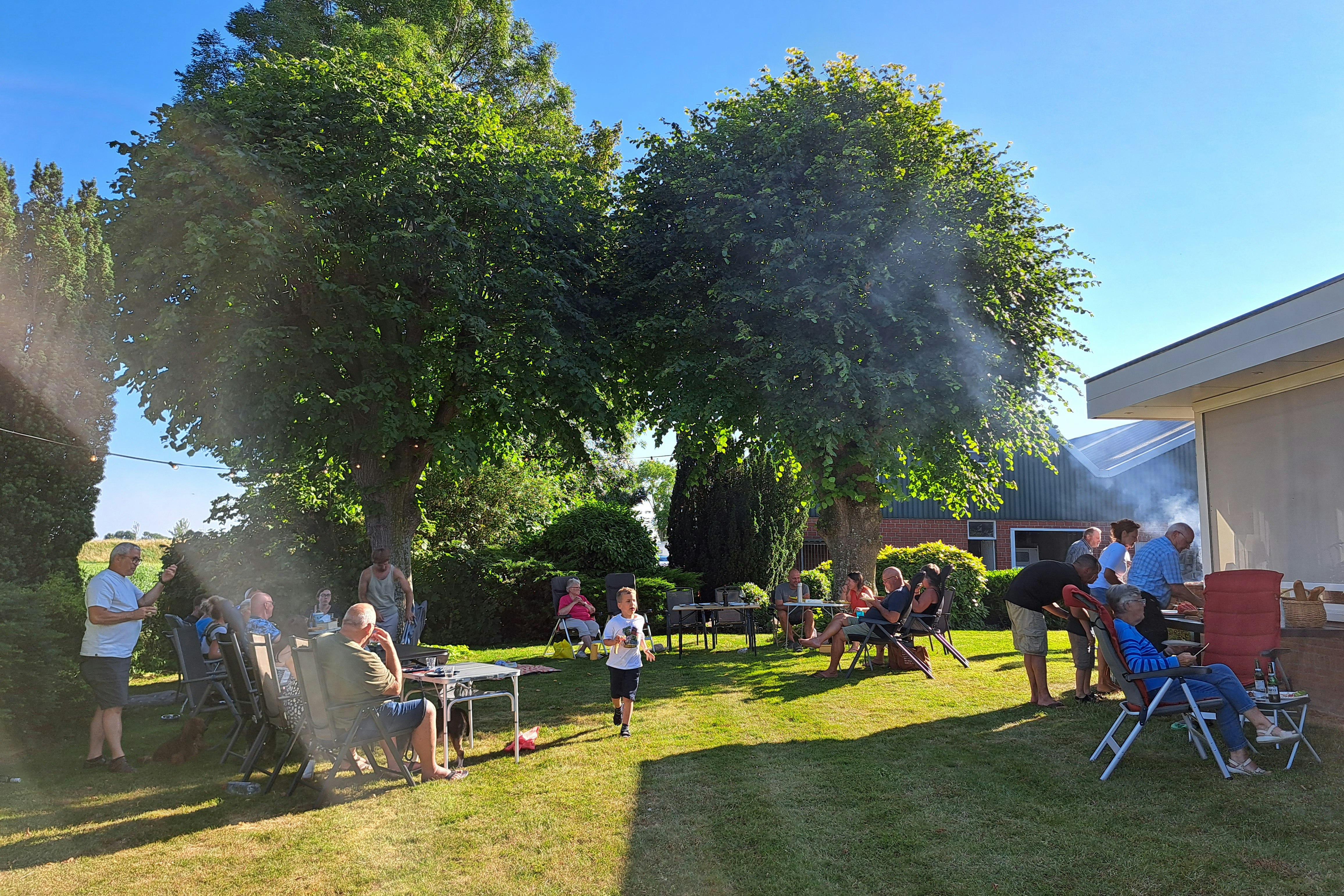 Minicamping Klaverwijk - Gäste sitzen gemeinsam auf dem Campingplatz und grillen