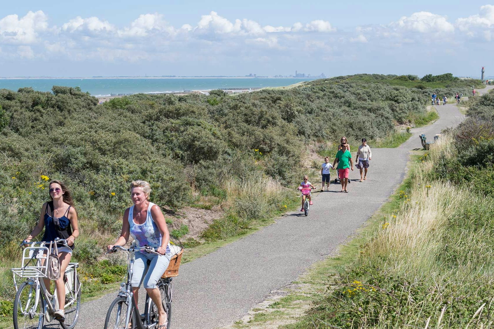 Molecaten Park Hoogduin  -  Camper mit Fahrrädern auf einem Gehweg am Campingplatz entlang der Nordsee