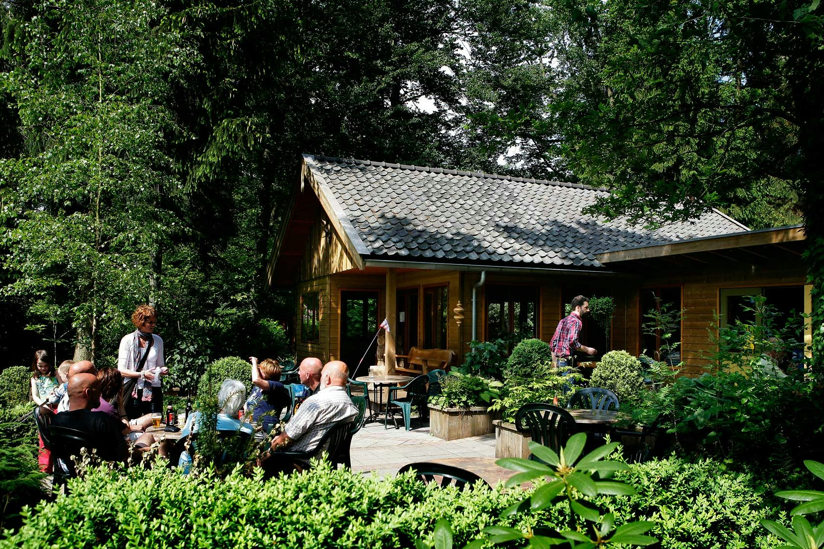 Molecaten Park Landgoed Molecaten  -  Camper auf der Terrasse vom Restaurant auf dem Campingplatz im Grünen