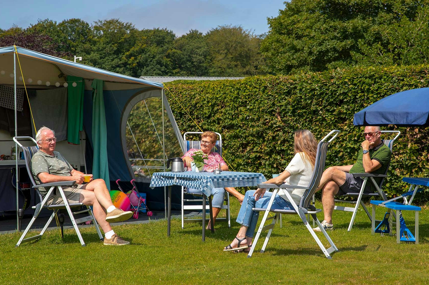 Molecaten Park Waterbos - Camper sitzen an einem Tisch vor ihrem Zelt