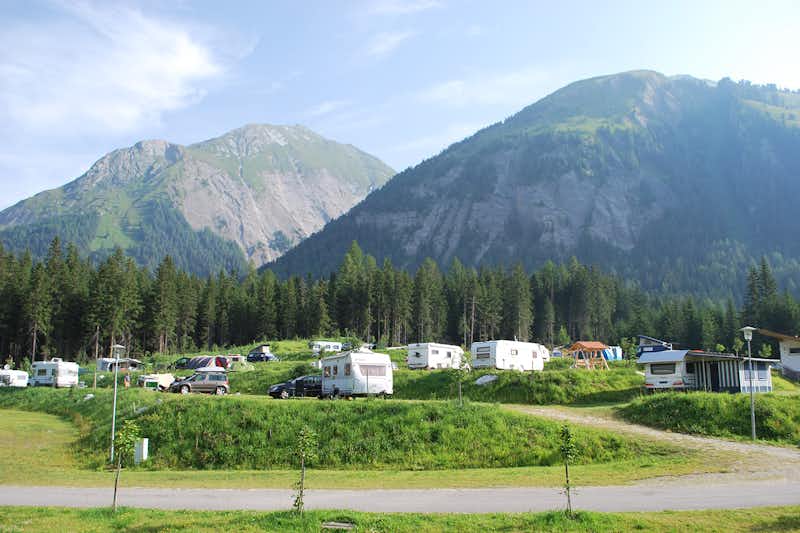 Nationalpark-Camping - Wohnmobil- und  Wohnwagenstellplätze auf der Wiese mit Blick auf die Berge auf dem Campingplatz