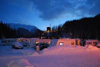 Nationalpark-Camping - Wohnmobil- und  Wohnwagenstellplätze im Schnee  mit Blick auf die Berge auf dem Campingplatz