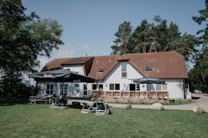 Wildwood Camping Rügen - Außenansicht Clubhouse mit Terrasse und Liegen