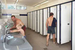 Naturcamping Ückeritz - Camper im Sanitärbereich vom Campingplatz mit Toiletten, Waschbecken und Spiegeln