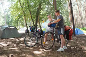 Naturcamping Ückeritz - Camper mit Fahrrädern auf dem Zeltplatz vom Campingplatz zwischen Bäumen