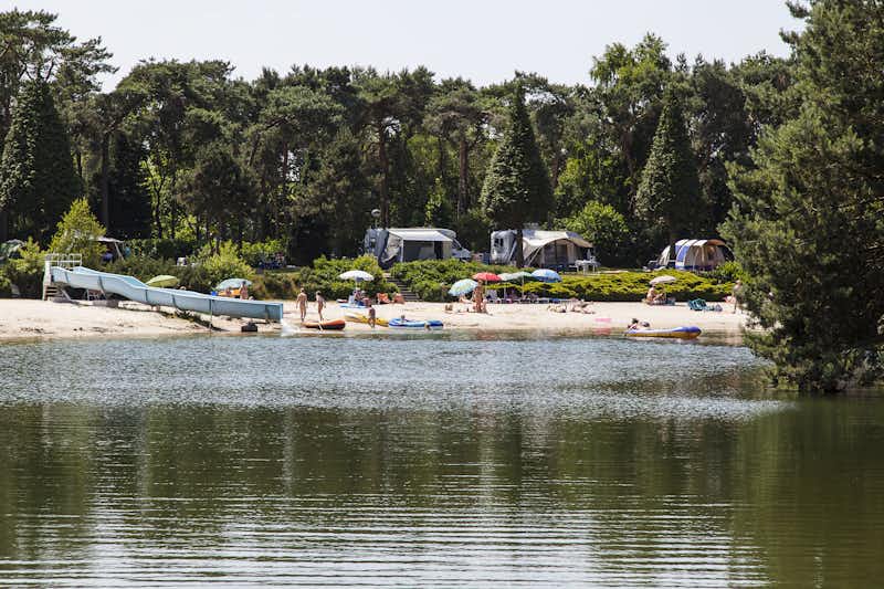 Naturistisch Recreatiepark Elsendorp  - Blick vom See auf den Campingplatz mit Strand
