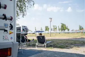 Neuer Strand Neusiedler See - Camper entspannen sich auf Liegestühlen auf ihrem Standplatz