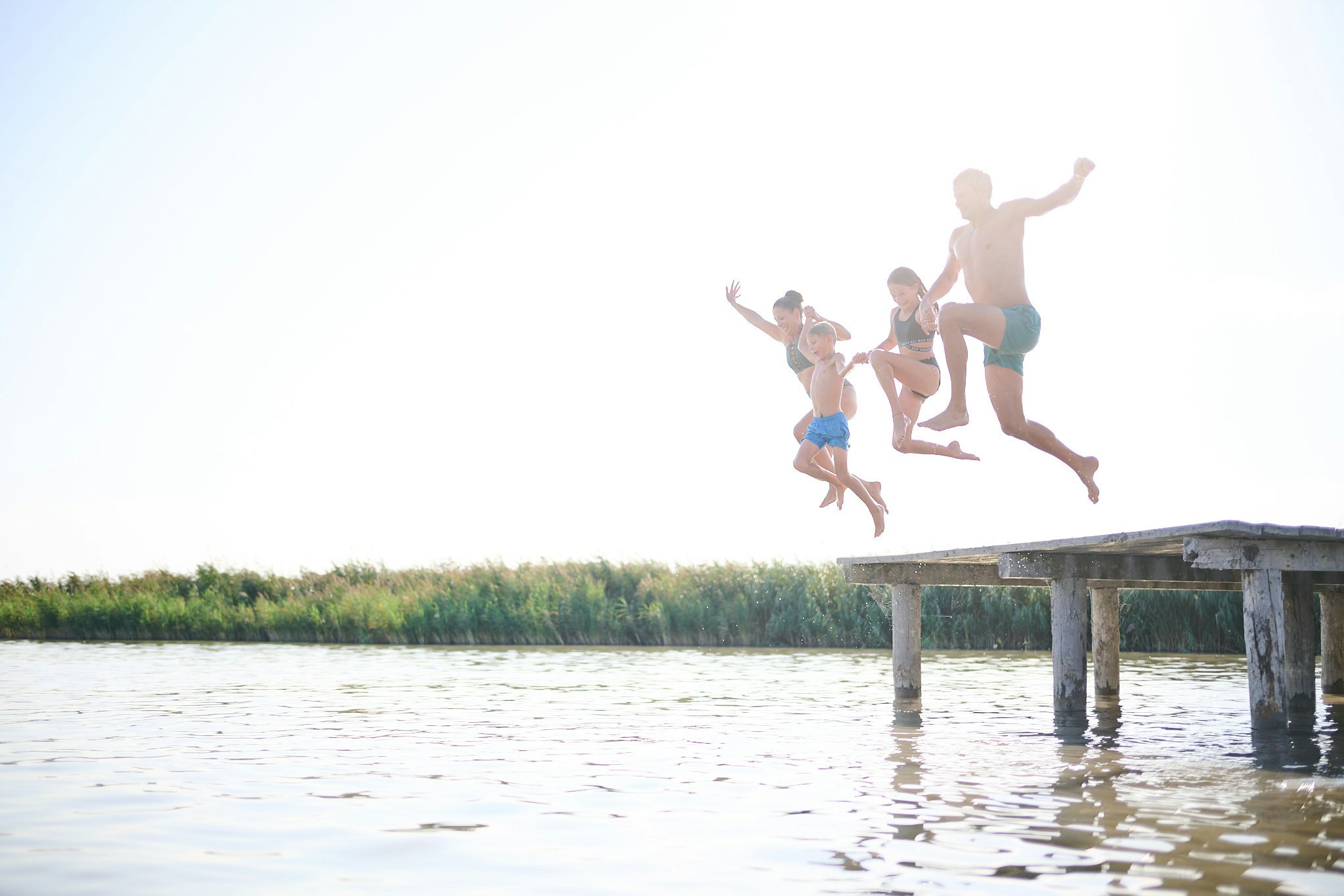 Neuer Strand Neusiedler See - Camper springen vom Steg in den See