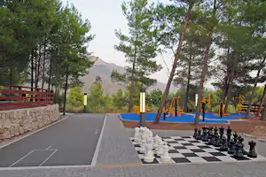 Nevio Camping - Schachpartie und Trainingsgerät im Schatten der Baüme auf dem Campingplatz