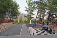 Nevio Camping -  Schachpartie und Trainingsgerät im Schatten der Baüme auf dem Campingplatz