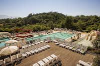 Norcenni Girasole Village  -  Pool vom Campingplatz mit Liegestühlen in der Sonne und Wasserrutsche