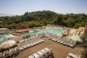 Norcenni Girasole Village - Pool vom Campingplatz mit Liegestühlen in der Sonne und Wasserrutsche