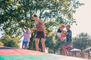 EuroParcs Kaatsheuvel Oostappen Vakantiepark Droomgaard - Familie auf der Hüpfburg auf dem Kinderspielplatz