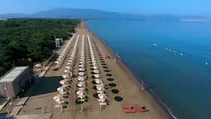 Orbetello Camping Village - Luftaufnahme des Badestrandes mit Liegestühlen und Sonnenschirmen