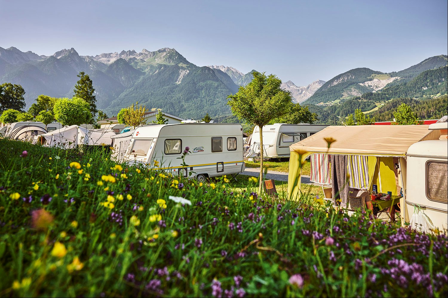 Panorama Camping Sonnenberg - Blick auf die Standplatzwiese mit Bergen im Hintergrund