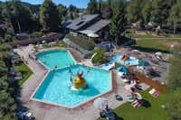 Pool mit Liegestühlen und Sonnenschirmen auf dem Campingplatz Panoramacamping Petite Suisse