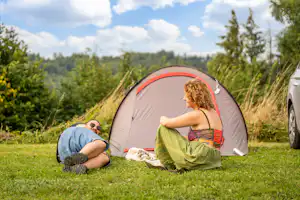 Papillon Bouillon - Camper sitzen vor ihrem Zelt auf der Wiese