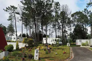 Parque de Campismo De Luso - Wohnmobile auf dem Stellplatz im Grünen mit kleinem Sitzgarten im Vordergrund