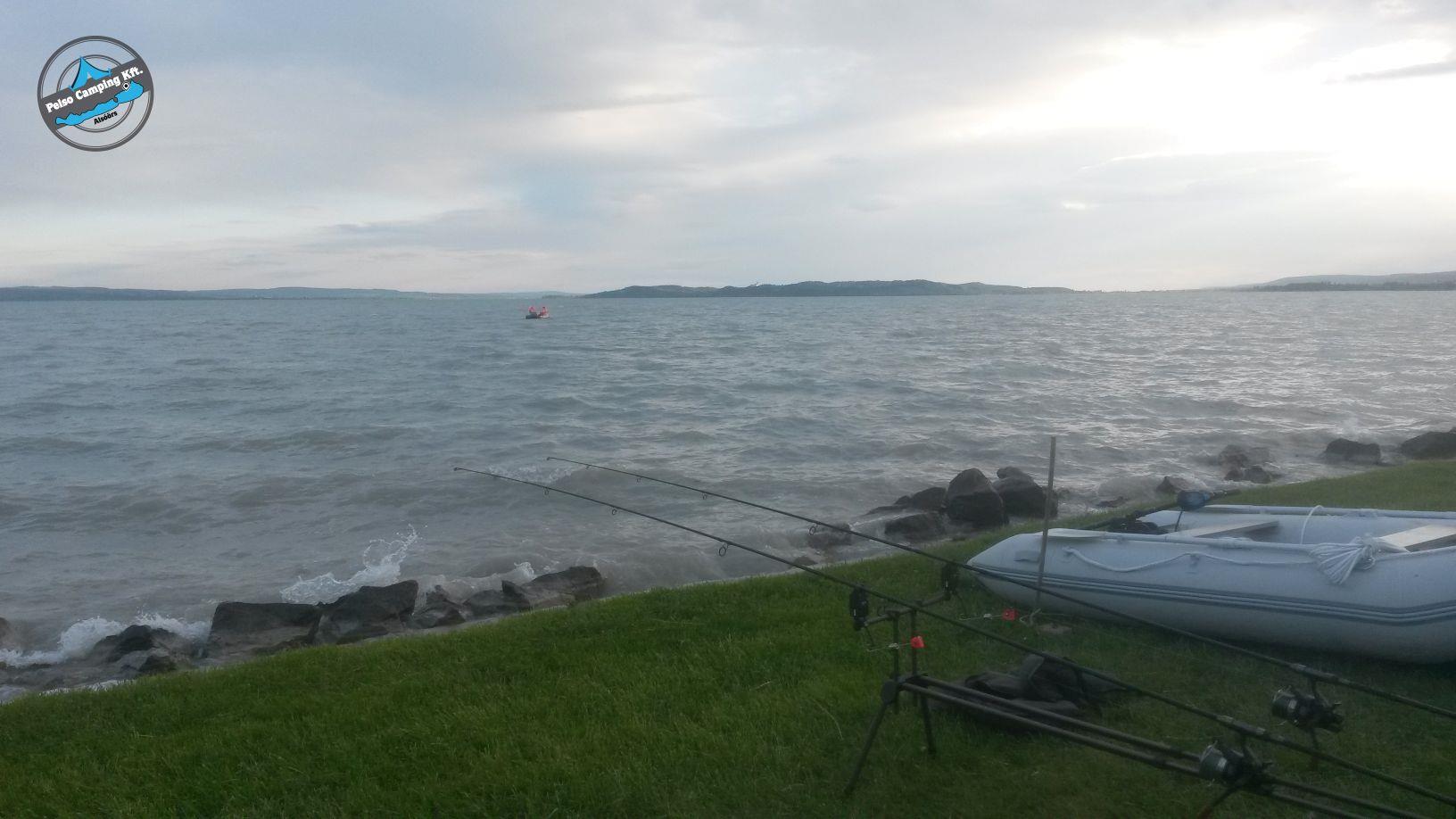 Zelt auf einer grünen Wiese direkt am Ufer, Blick auf das Meer und den felsigen Strand.