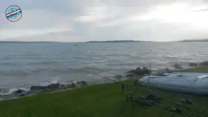 Zelt auf einer grünen Wiese direkt am Ufer, Blick auf das Meer und den felsigen Strand.