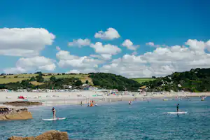 Pentewan Sands Holiday Park - Camper beim Baden und Stand Up Paddling am Strand vom Campingplatz