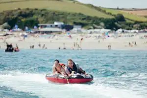 Pentewan Sands Holiday Park - Schlachboot fahrende Camper am Strand vom Campingplatz