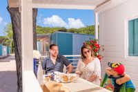 Pineta sul Mare Camping Village - Familie frühstückt gemeinsam auf der Terrasse ihres Mobilheims