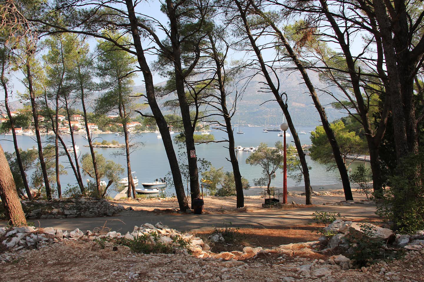 Port 9 Camping  -  Wohnwagen- und Zeltstellplatz zwischen Bäumen mit Blick auf das Meer