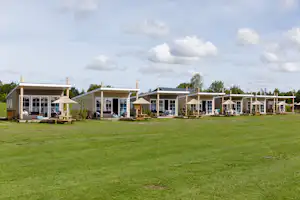 RCN Camping Zeewolde - Glamping Bungalows mit überdachter Veranda und Sonnenschirm