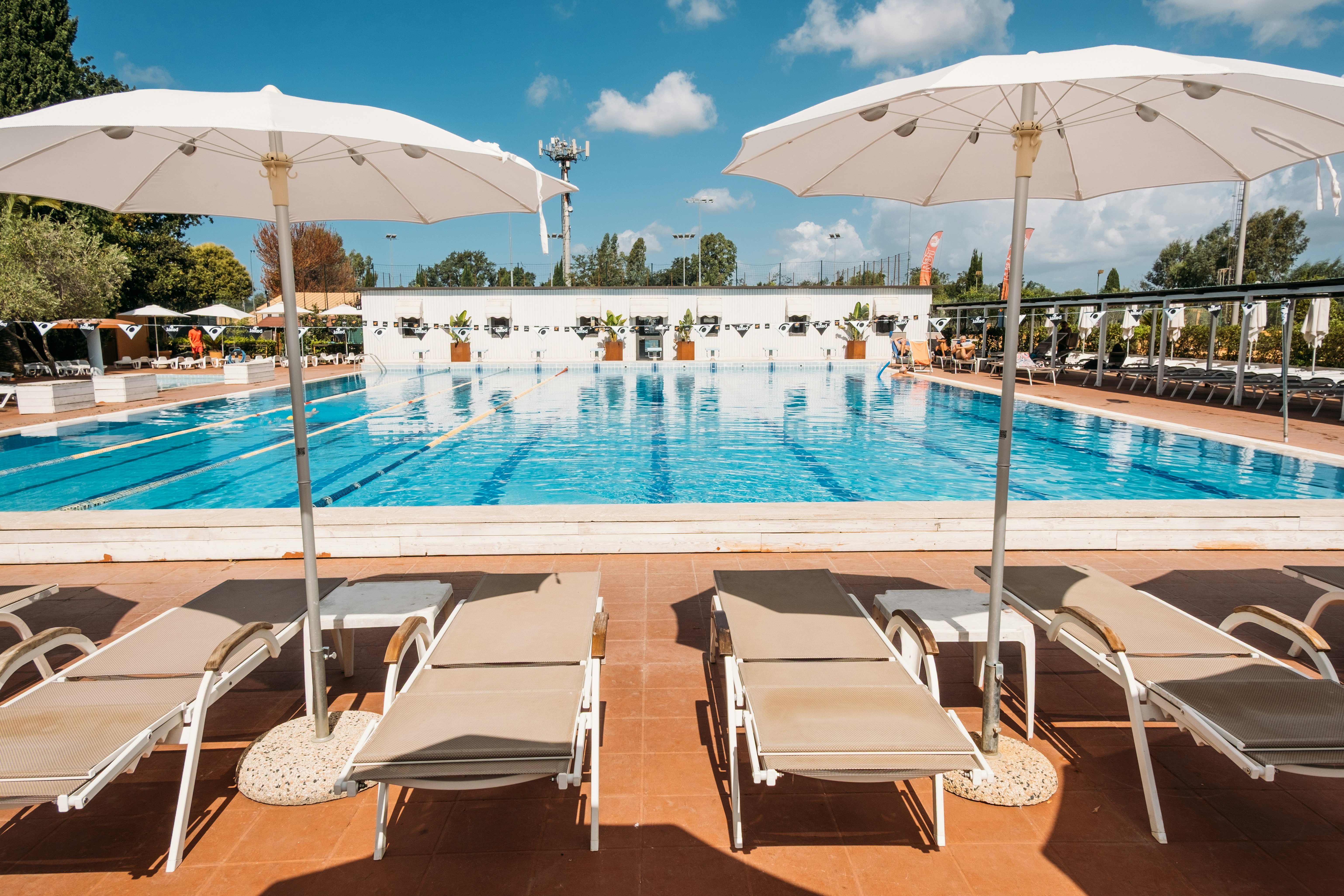 Real Village Roma - Pool im Freien mit Liegestühlen und Sonnenschirmen