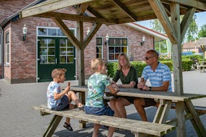 Recreatiecentrum De Vogel - Familie sitzt an einem Picknicktisch und isst Eis