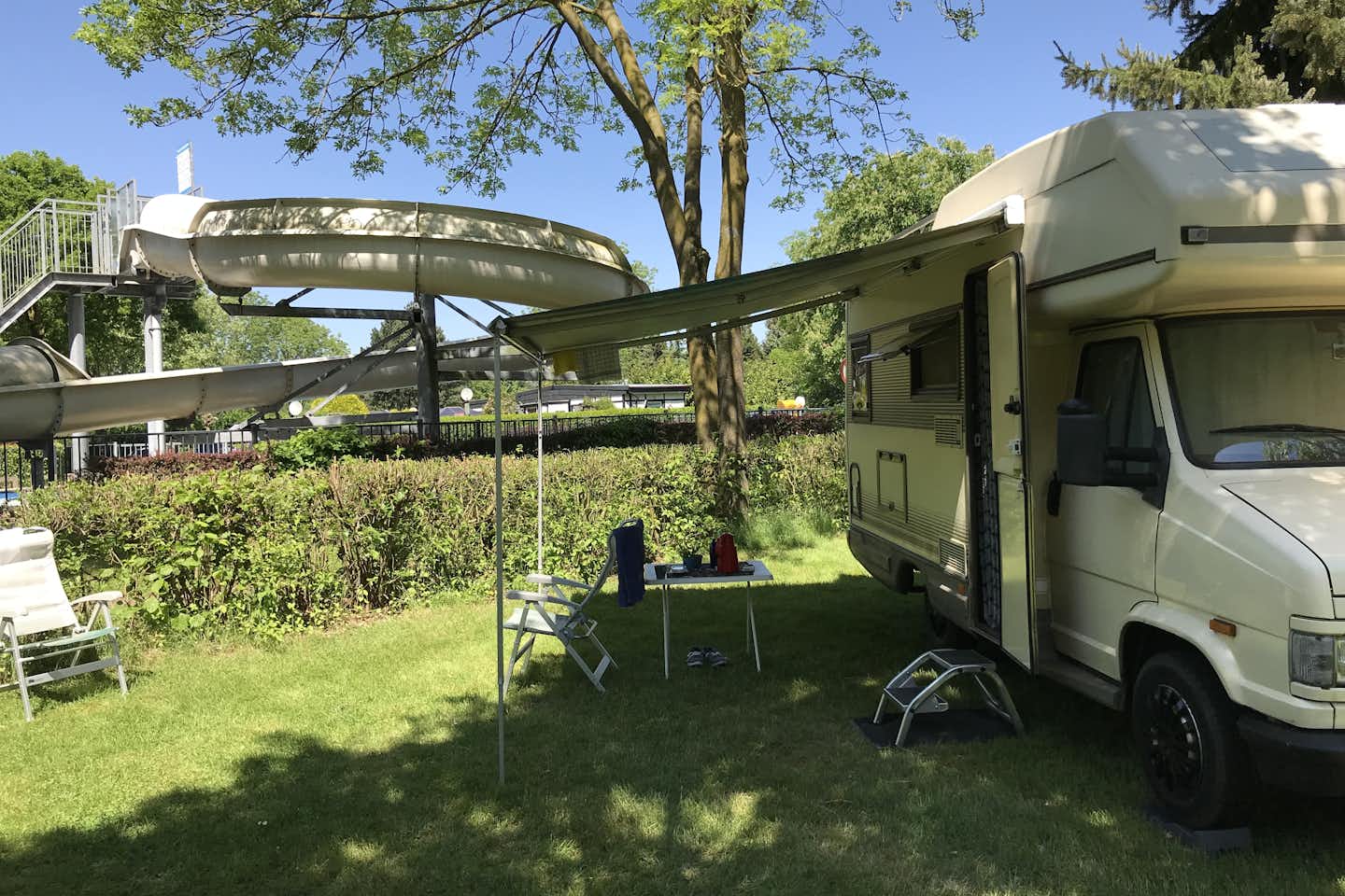 Recreatiepark Kasteel Ooijen  -  Wohnmobil auf dem Stellplatz vom Campingplatz mit Blick auf die Wasserrutsche vom Pool