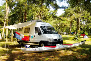 Regenbogen Born - Wohnwagen auf dem Stellplatz vom Campingplatz zwischen Bäumen