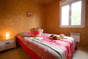 Résidence les chalets de la Vingeanne - Doppelbett im Schlafzimmer eines Mobilheims