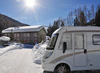 RinerLodge Camping - Schneebedeckte Wohnwagen in winterlicher Berglandschaft