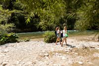 River Camping Bled - Camperinnen spazieren am Flussufer auf dem Gelände vom Campingplatz