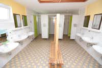Rosen-Camp Kniese - Innenraum des Sanitärgebäudes mit Waschbecken und Duschkabinen