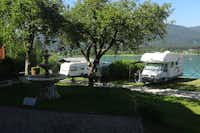 Seeterrassencamping Ried - Wohnwagenstellplatz zwischen Weg und See auf der Wiese der Campingplatzanlage