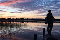 Silkeborg Sø Camping - See im Abendrot mit Steg im Vordergrund auf dem ein Mensch steht
