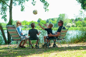 Siócamping - Familie sitzt auf Campingstühlen in der Natur