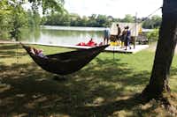 Sites et Paysages Camping Saint-Louis  - Camper in einer Hängematte am See vom Campingplatz