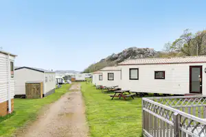 Siviks Camping - Mobilheime vom Campingplatz mit Picknicktischen auf grüner Wiese