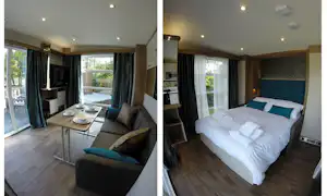 Modernes Camping-Bungalow Schlafzimmer mit Doppelbett, Vorhängen, Holzpaneelen und Deckenlampen, Blick auf die Terrasse.