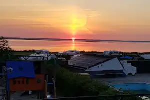 Sølyst Camping - Blick vom Campingplatz mit Spielplatz und Pool auf den Fjord bei Sonnenuntergang
