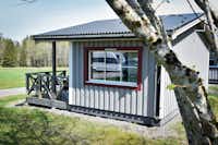 Stenrösets Camping - Blick auf ein Mobilheim mit überdachter Terrasse auf dem Campingplatz