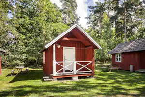Nordic Camping Stensö - Mobilheime vom Campingplatz mit Veranden und Picknicktischen auf grüner Wiese